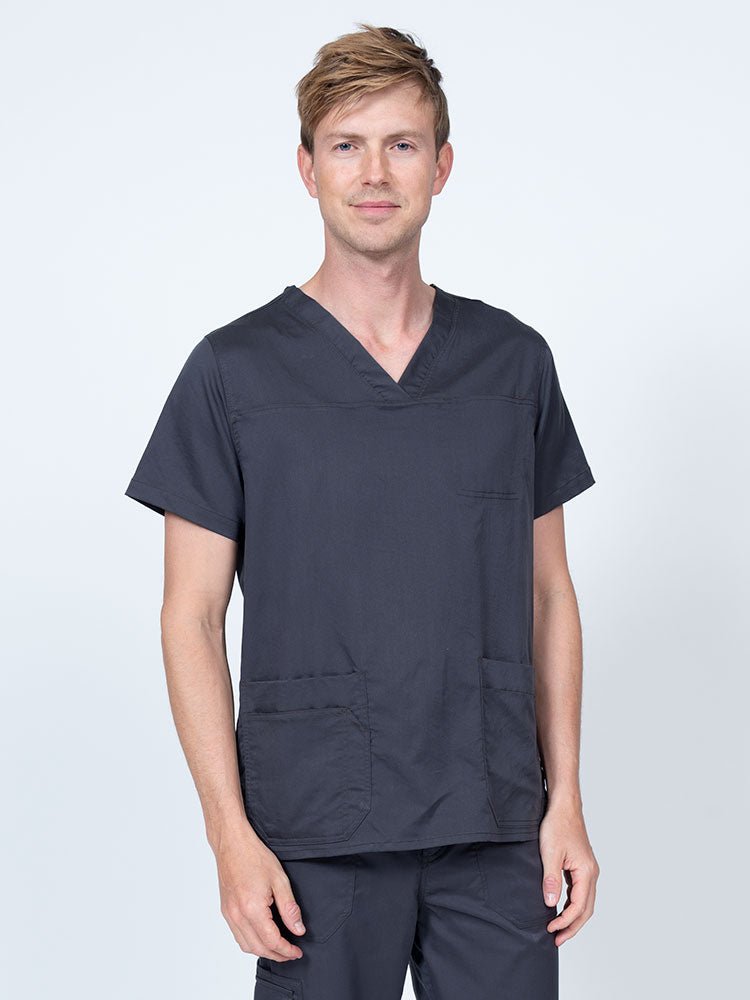 Male healthcare professional wearing an Epic by MedWorks Men's Scrub Top in pewter with 2 front patch pockets and 1 exterior cell phone pocket on the wearer's right side.