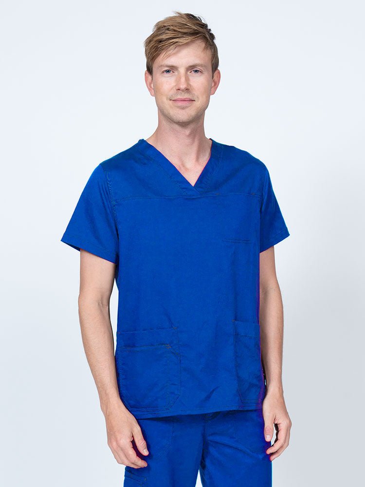 Male healthcare professional wearing an Epic by MedWorks Men's Scrub Top in royal with 2 front patch pockets and 1 exterior cell phone pocket on the wearer's right side.