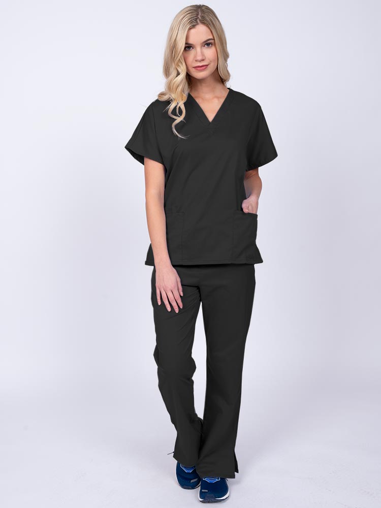 Young woman wearing an Epic by MedWorks Unisex Scrub Top in black featuring a V-neckline & short sleeves.