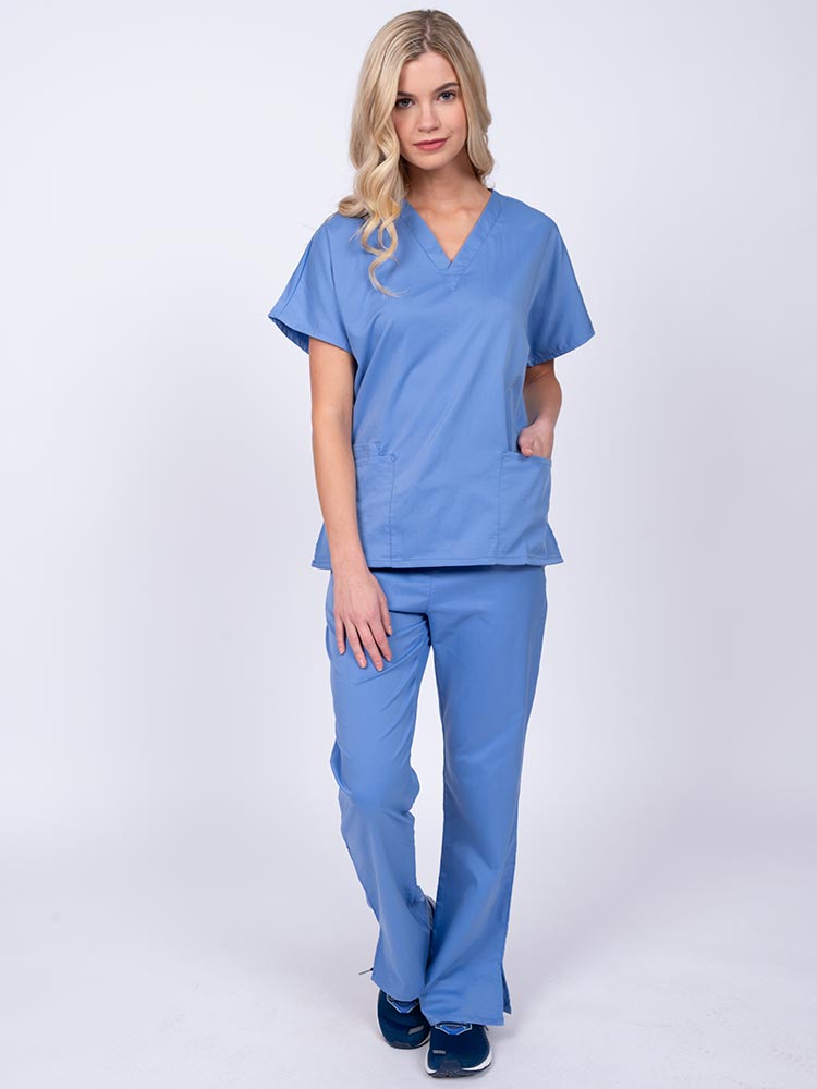 Young woman wearing an Epic by MedWorks Unisex Scrub Top in ceil featuring a V-neckline & short sleeves.