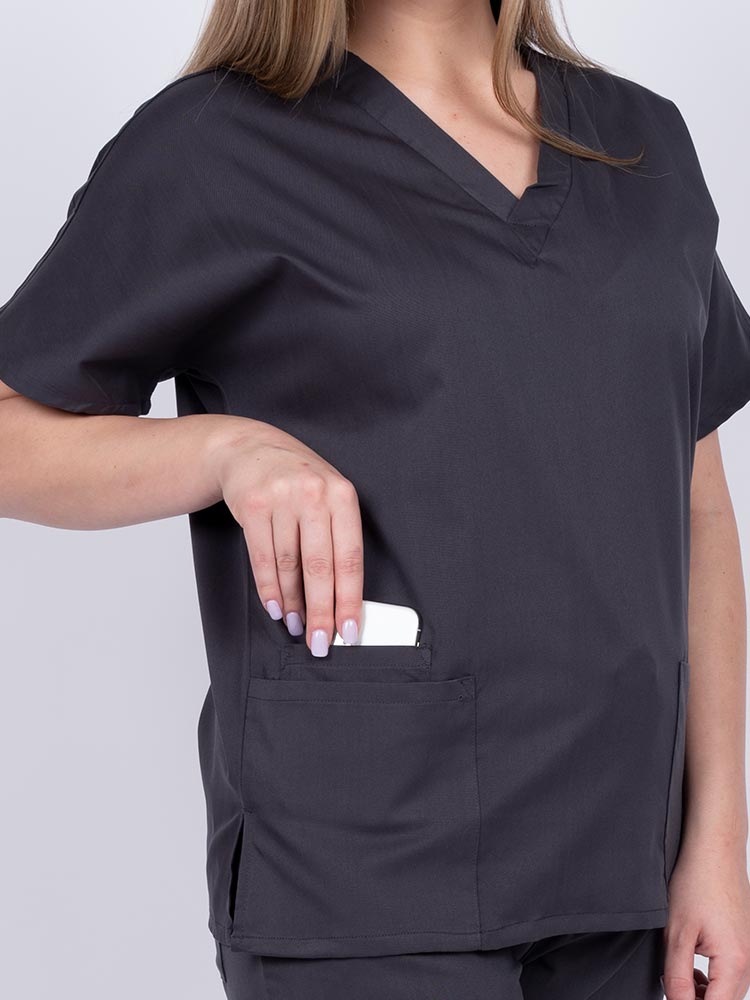 Woman wearing an Epic by MedWorks Unisex V-Neck Scrub Top in pewter with 2 patch pockets and a cell phone pocket.