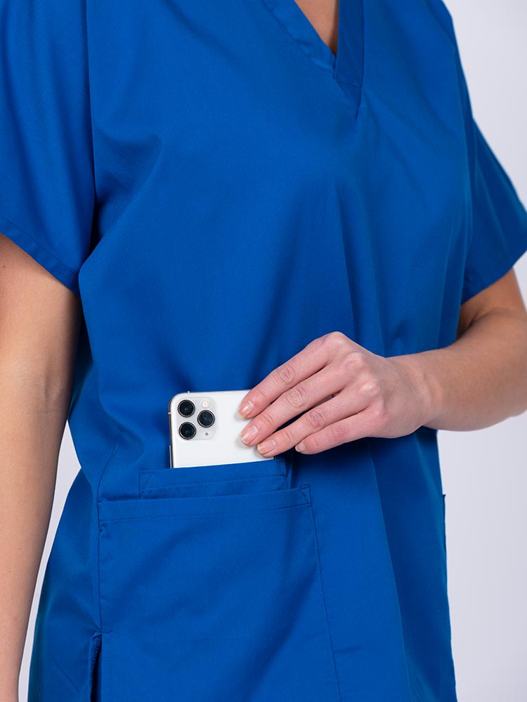 Woman wearing an Epic by MedWorks Unisex V-Neck Scrub Top in royal with 2 patch pockets and a cell phone pocket.