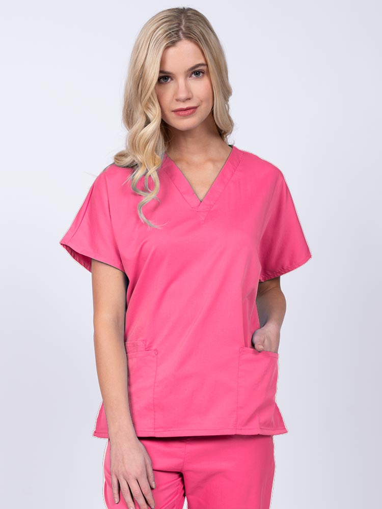 Young nurse wearing an Epic by MedWorks Unisex V-Neck Scrub Top in shocking pink with a unique, easy care fabric made of 77% polyester, 21% Viscose and 2% Spandex.