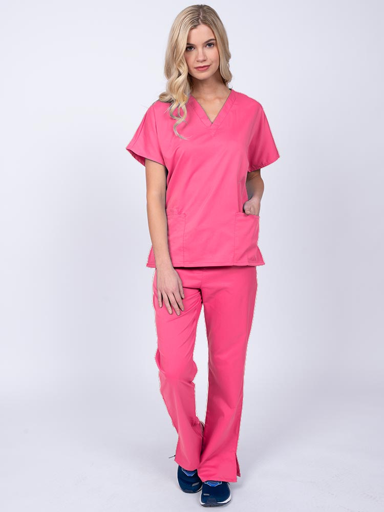 Young woman wearing an Epic by MedWorks Unisex Scrub Top in shocking pink featuring a V-neckline & short sleeves.