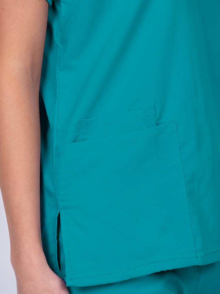 Woman wearing an Epic by MedWorks Unisex V-Neck Scrub Top in teal with 2 patch pockets and a cell phone pocket.