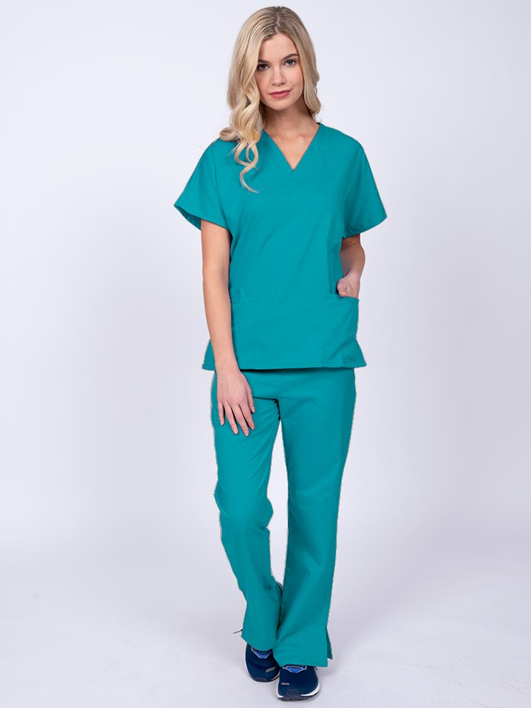 Young woman wearing an Epic by MedWorks Unisex Scrub Top in teal featuring a V-neckline & short sleeves.