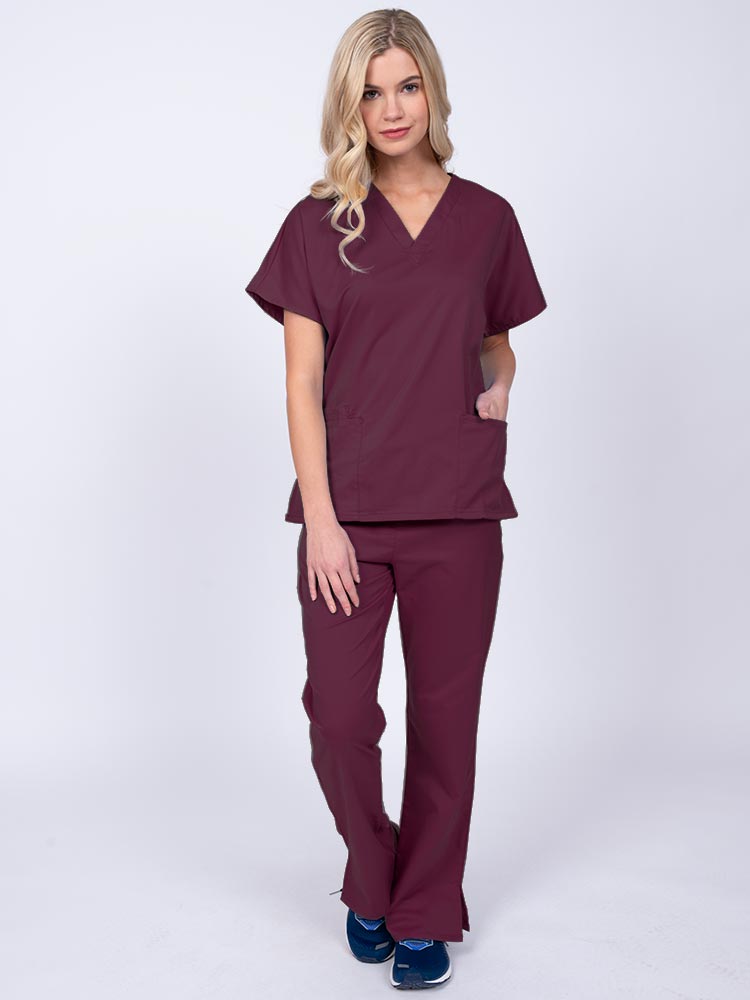 Young woman wearing an Epic by MedWorks Unisex Scrub Top in wine featuring a V-neckline & short sleeves.