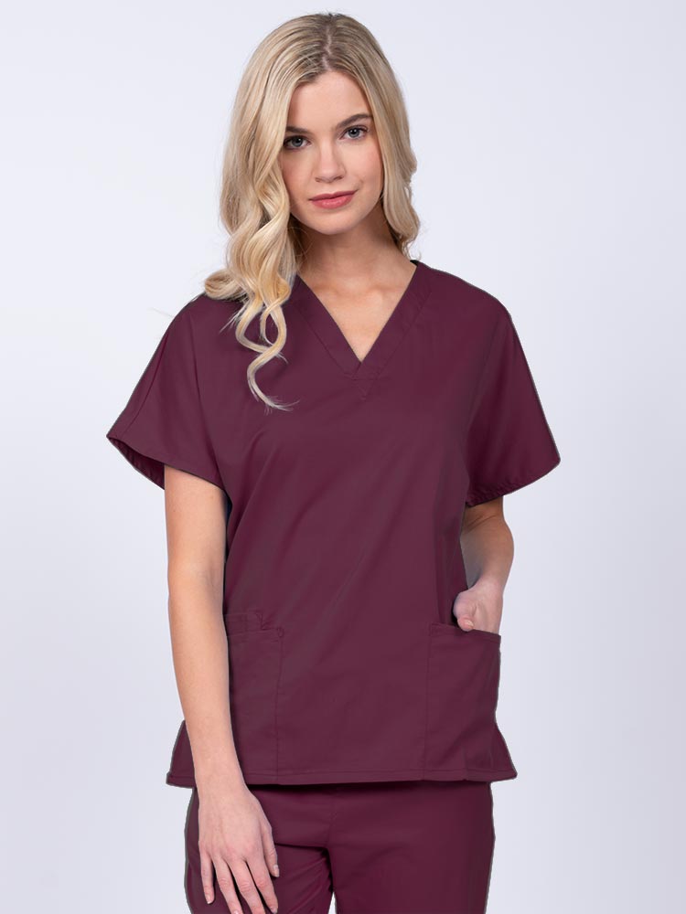 Young nurse wearing an Epic by MedWorks Unisex V-Neck Scrub Top in wine with a unique, easy care fabric made of 77% polyester, 21% Viscose and 2% Spandex.