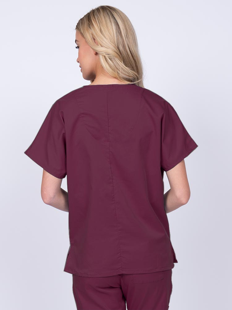 Woman wearing an Epic by MedWorks Unisex V-Neck Scrub Top in wine with a center back length of 27.5".