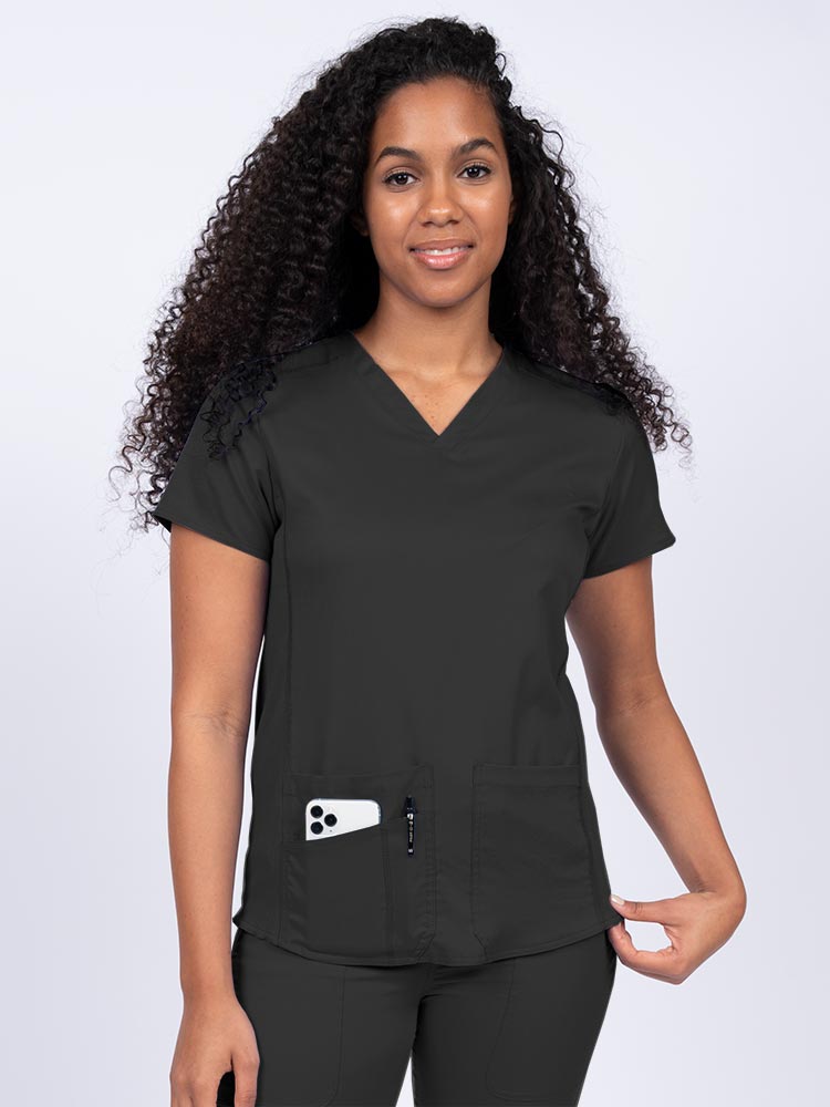 Nurse wearing an Epic by MedWorks Women's Blessed Scrub Top in black with a V-neckline & short sleeves.