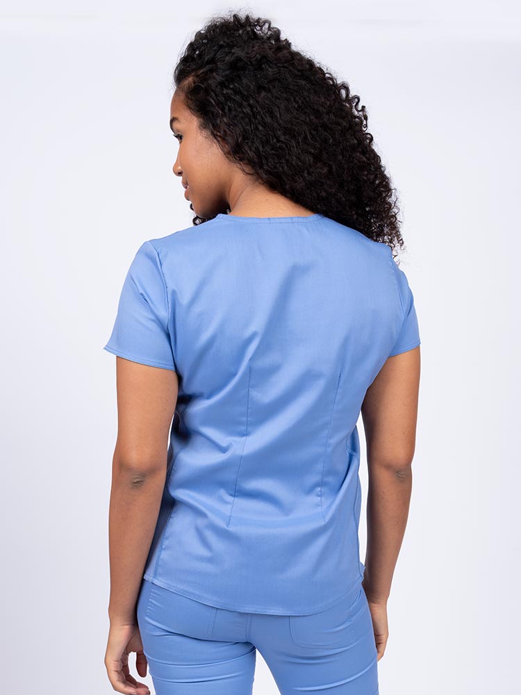 Woman wearing an Epic by MedWorks Women's Blessed Scrub Top in ceil  with a pleated back for a flattering fit.