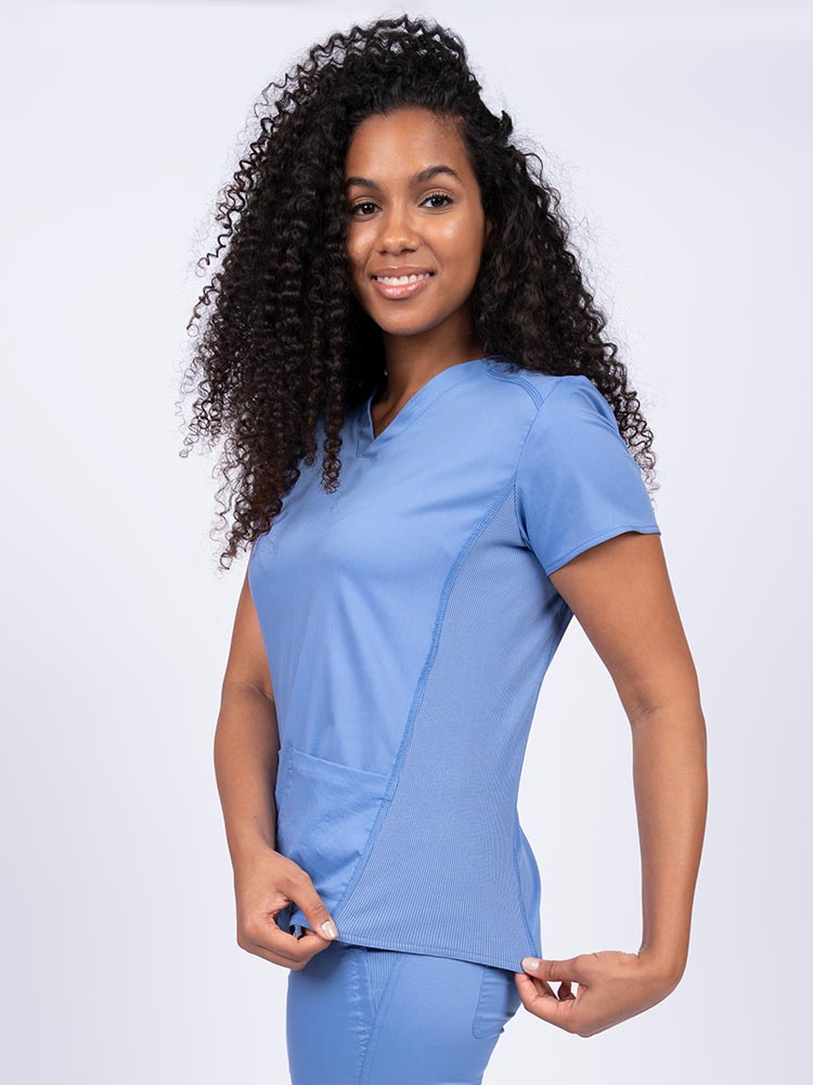 Nurse wearing an Epic by MedWorks Women's Blessed Scrub Top in ceil with stylish seaming throughout.