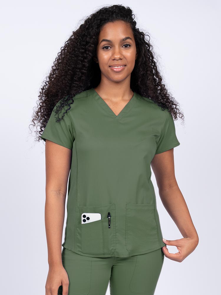Nurse wearing an Epic by MedWorks Women's Blessed Scrub Top in olive with a V-neckline & short sleeves.