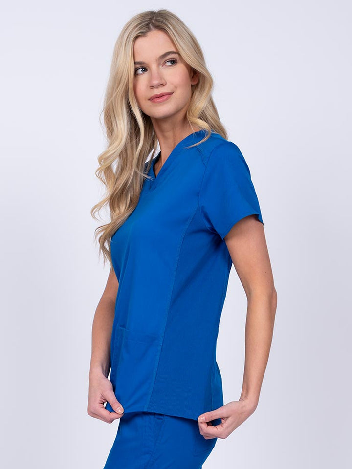 Nurse wearing an Epic by MedWorks Women's Blessed Scrub Top in royal with stylish seaming throughout.