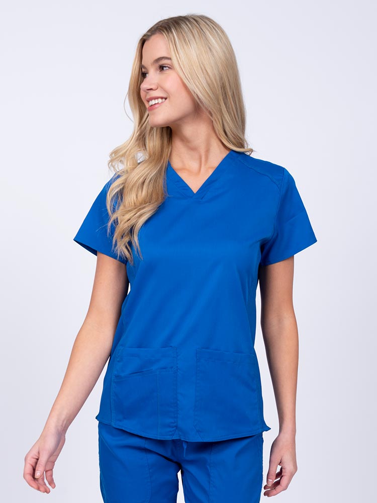 Nurse wearing an Epic by MedWorks Women's Blessed Scrub Top in royal with a V-neckline & short sleeves.