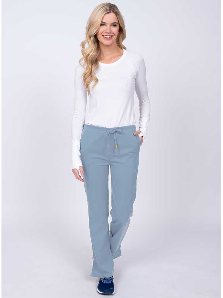 Woman wearing an Epic by MedWorks Women's Drawstring Flare Leg Scrub Pant in blue fog with 2 front slash pockets & 1 back pocket.