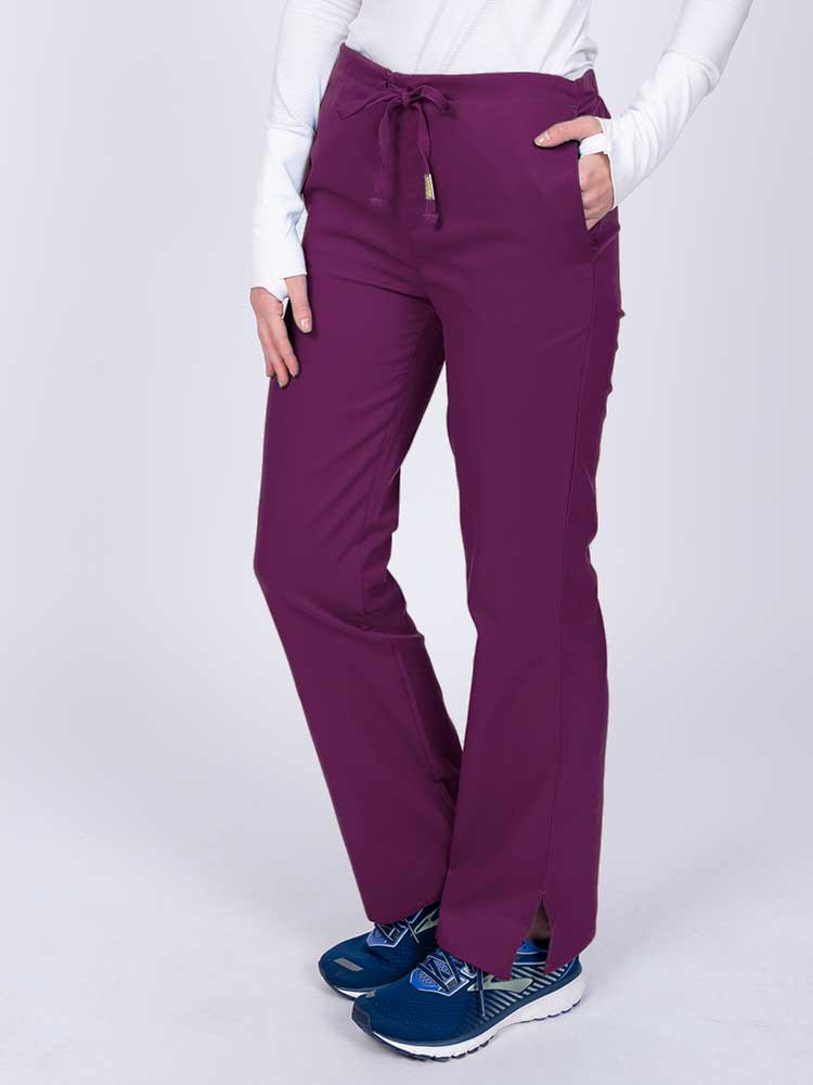 Nurse wearing an Epic by MedWorks Women's Drawstring Flare Leg Scrub Pant in eggplant with side slits for additional mobility.