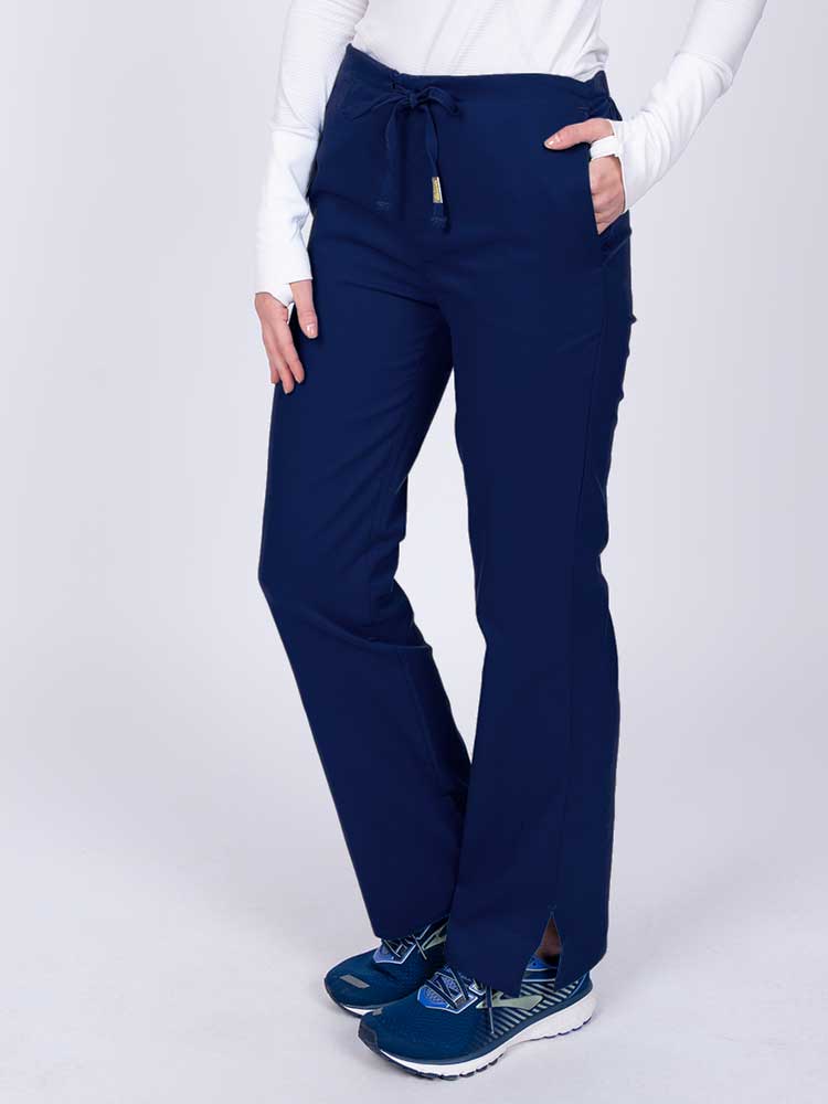 Nurse wearing an Epic by MedWorks Women's Drawstring Flare Leg Scrub Pant in navy with side slits for additional mobility.