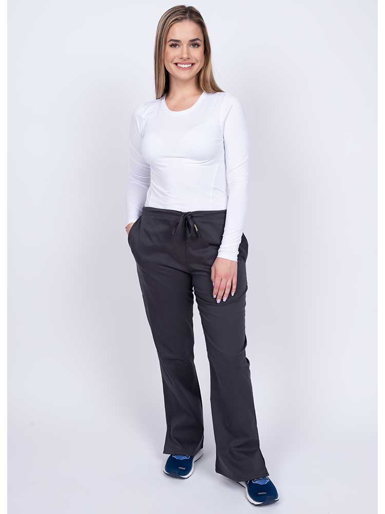 Woman wearing an Epic by MedWorks Women's Drawstring Flare Leg Scrub Pant in pewter with 2 front slash pockets & 1 back pocket.