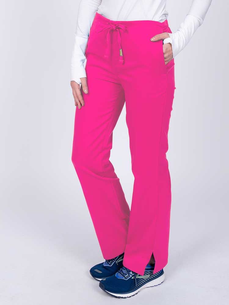 Nurse wearing an Epic by MedWorks Women's Drawstring Flare Leg Scrub Pant in shocking pink with side slits for additional mobility.
