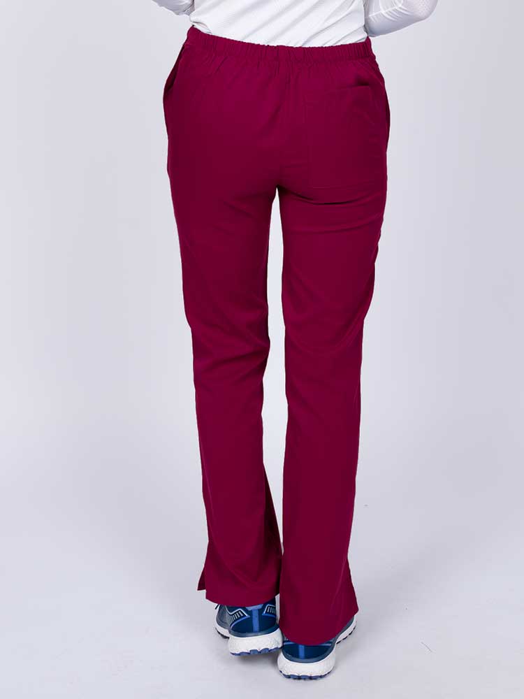 Young healthcare worker wearing an Epic by MedWorks Women's Drawstring Flare Leg Scrub Pant in wine featuring a drawstring waist with back elastic.