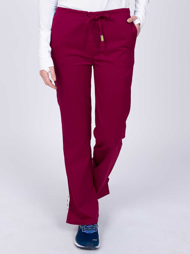 Young nurse wearing an Epic by MedWorks Women's Drawstring Flare Leg Scrub Pant in wine with unique stretch fabric made of 77% Polyester, 21% Viscose, 2% Spandex.