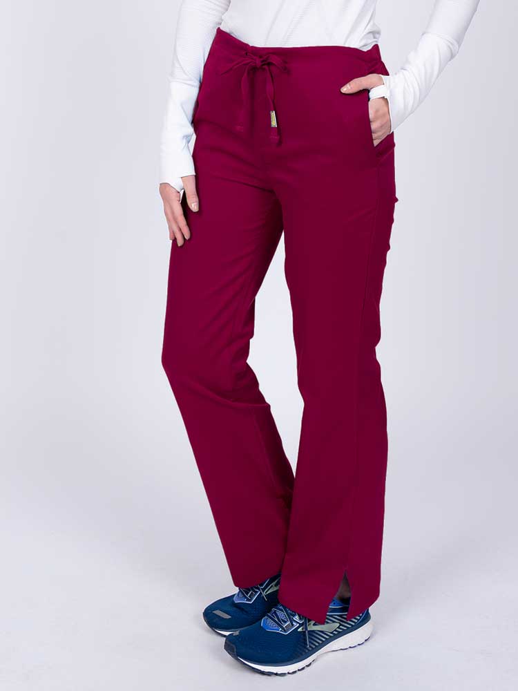Nurse wearing an Epic by MedWorks Women's Drawstring Flare Leg Scrub Pant in wine with side slits for additional mobility.