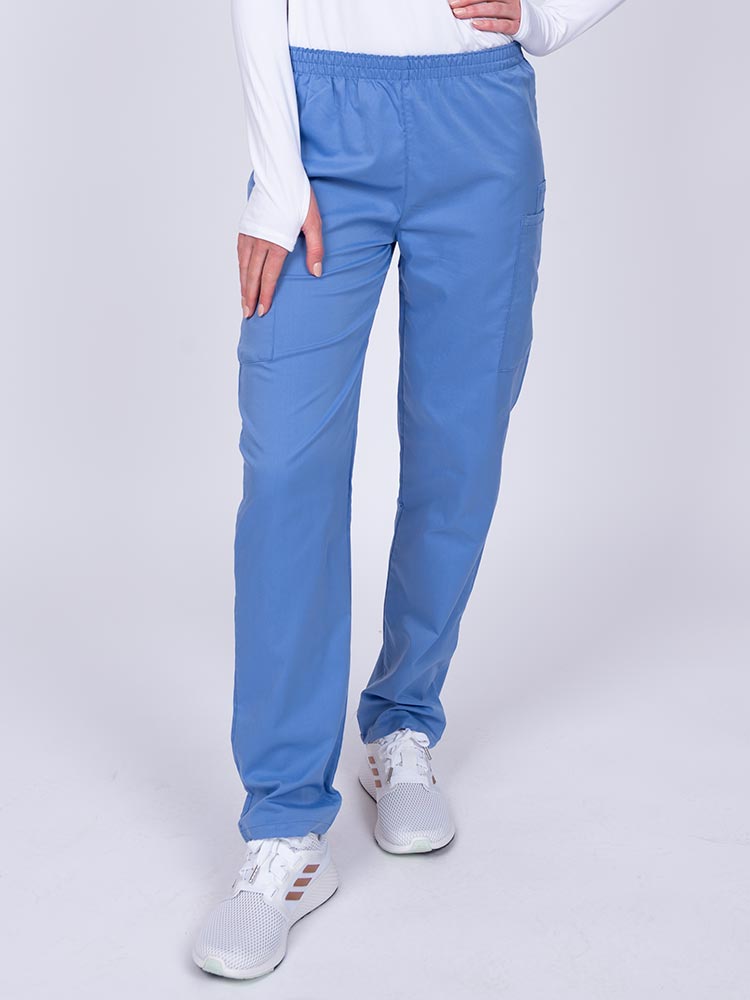 Young woman wearing an Epic by MedWorks Women's Elastic Waist Scrub Pant in ceil featuring a tapered leg and elastic waist.