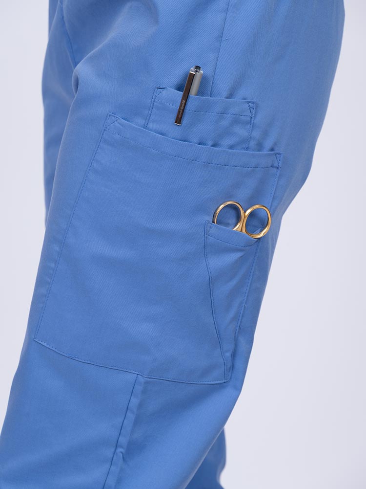 Young nurse wearing an Epic by MedWorks Women's Elastic Waist Scrub Pant in ceil with 1 cell phone pocket and 1 outside pen slot on the wearer's left side.