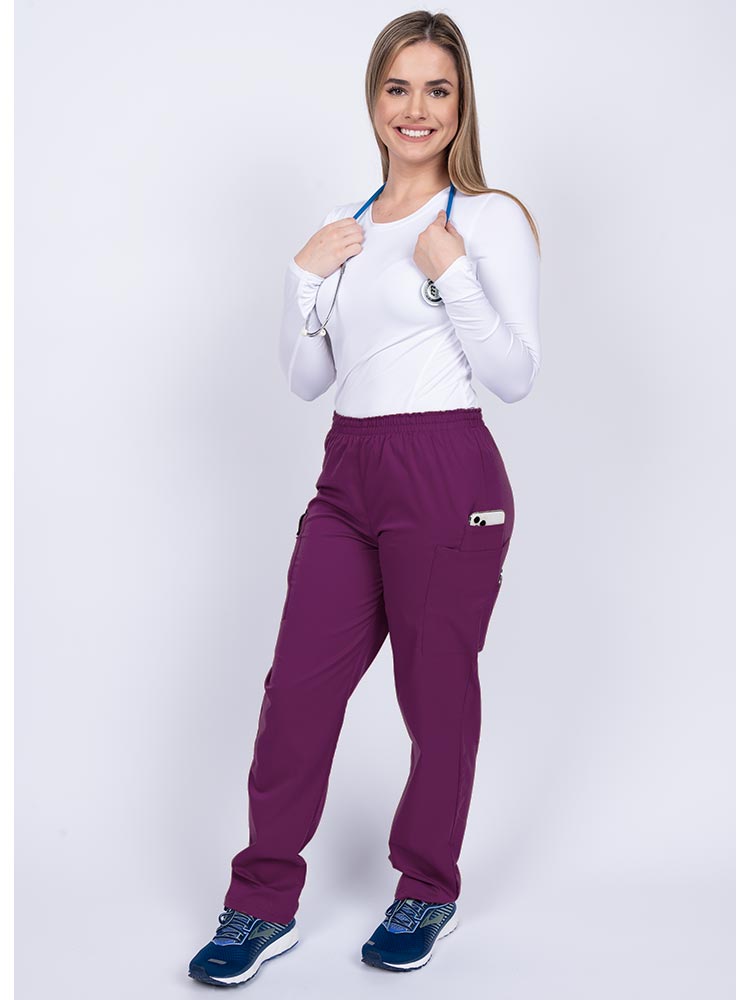 Healthcare worker wearing an Epic by MedWorks Women's Elastic Waist Scrub Pant in eggplant with 1 cell phone pocket & and 1 pen slot.