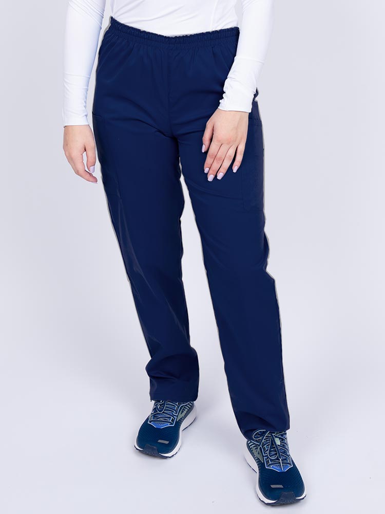 Young woman wearing an Epic by MedWorks Women's Elastic Waist Scrub Pant in navy featuring a tapered leg and elastic waist.
