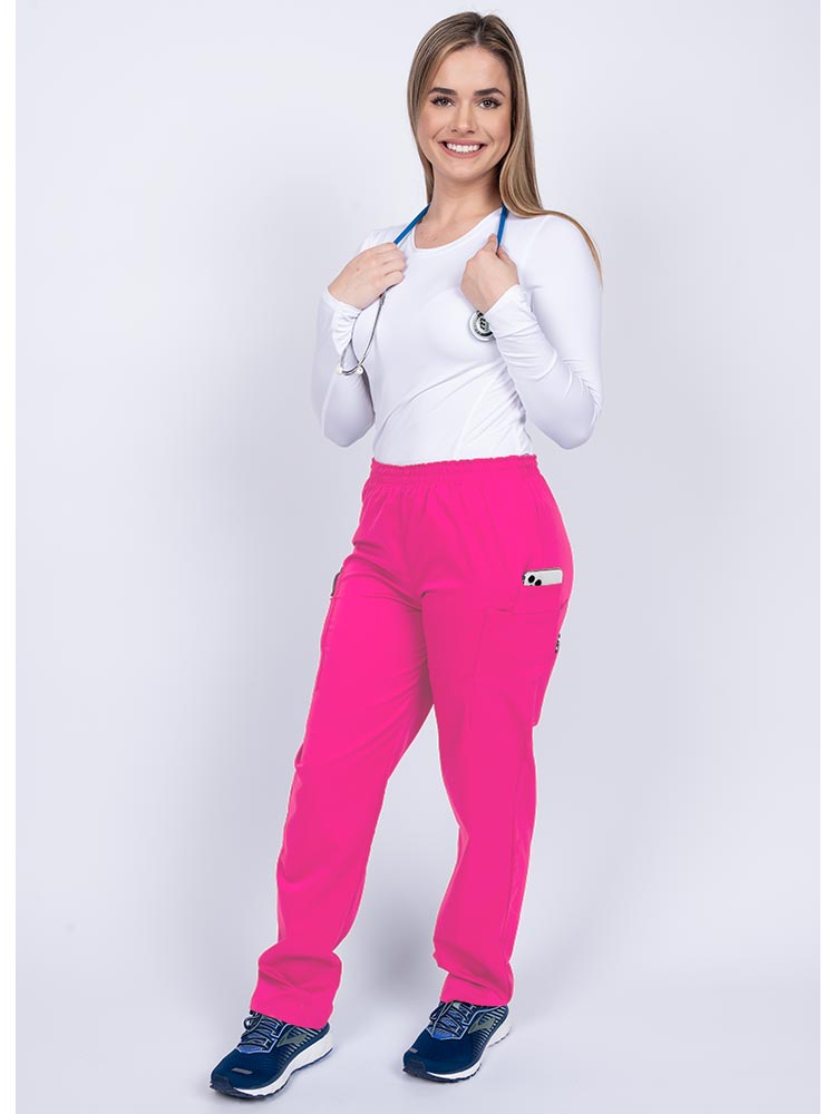 Healthcare worker wearing an Epic by MedWorks Women's Elastic Waist Scrub Pant in shocking pink with 1 cell phone pocket & and 1 pen slot.