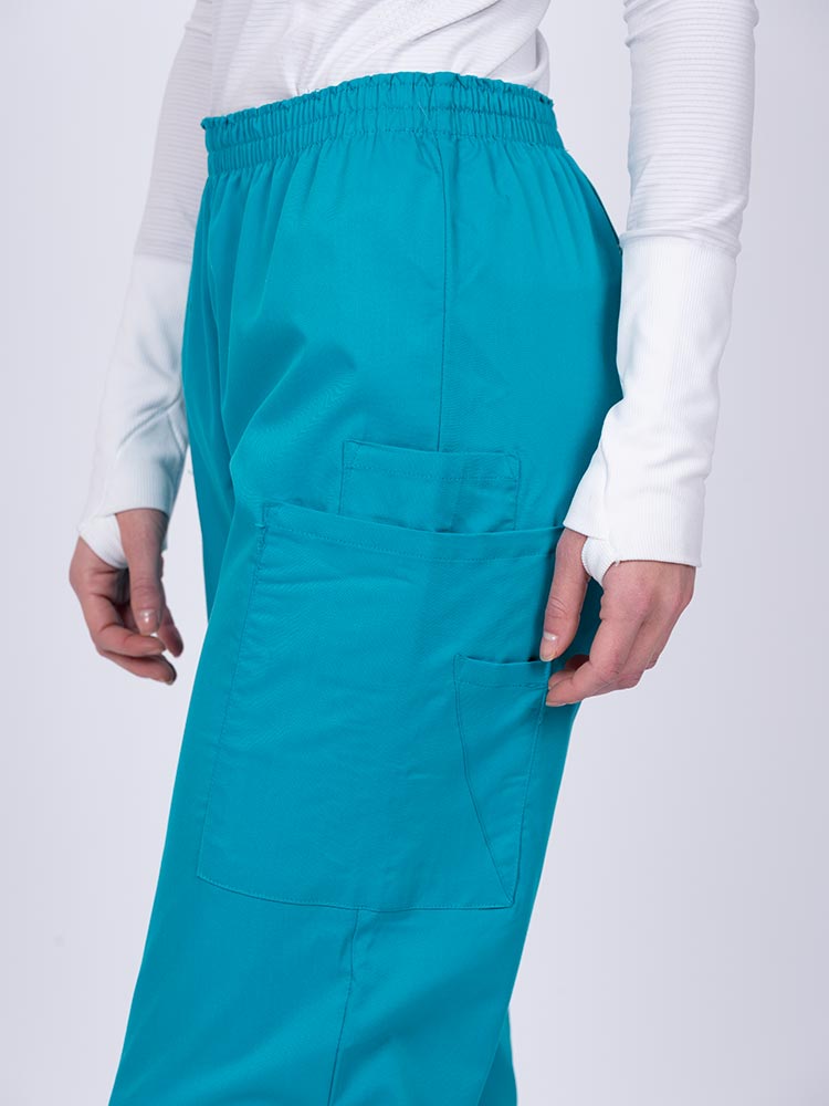 Healthcare worker wearing an Epic by MedWorks Women's Elastic Waist Scrub Pant in teal with 1 cell phone pocket & and 1 pen slot.