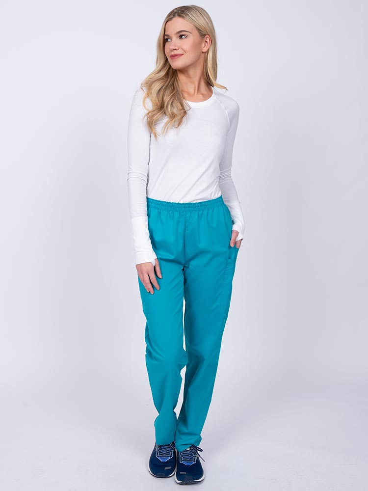 Young woman wearing an Epic by MedWorks Women's Elastic Waist Scrub Pant in teal featuring a tapered leg and elastic waist.