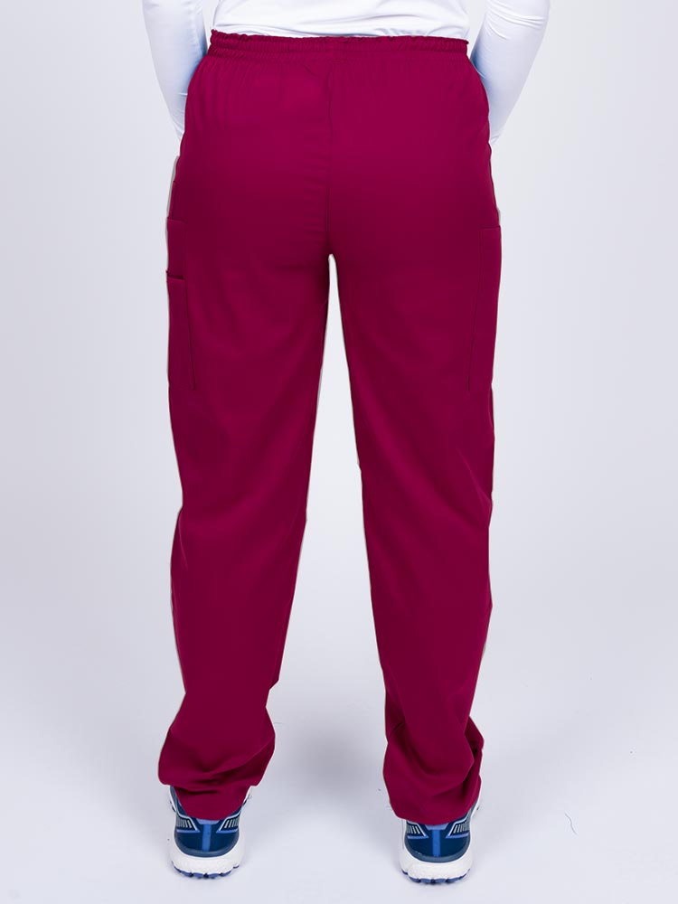 Woman wearing an Epic by MedWorks Women's Elastic Waist Scrub Pant in wine with two cargo pockets.
