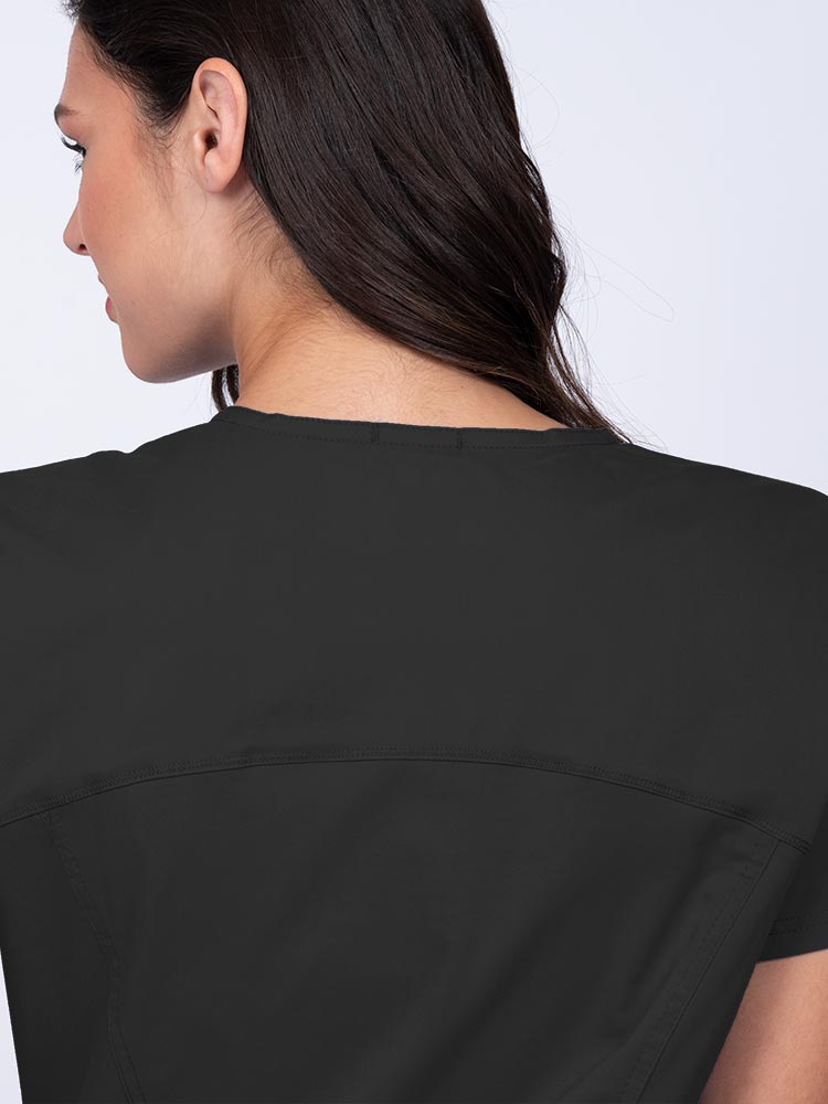 Young woman wearing an Epic by MedWorks Women's Knit Collar Mock Wrap Scrub Top in black with a back yoke to ensure a flattering fit.