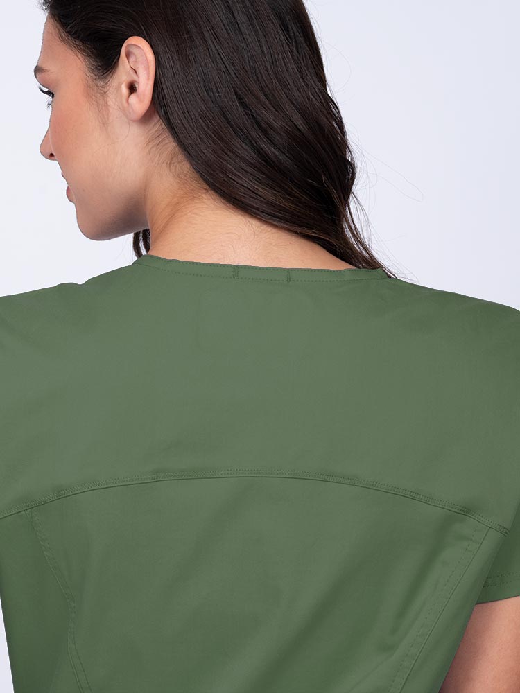 Young woman wearing an Epic by MedWorks Women's Knit Collar Mock Wrap Scrub Top in olive with a back yoke to ensure a flattering fit.