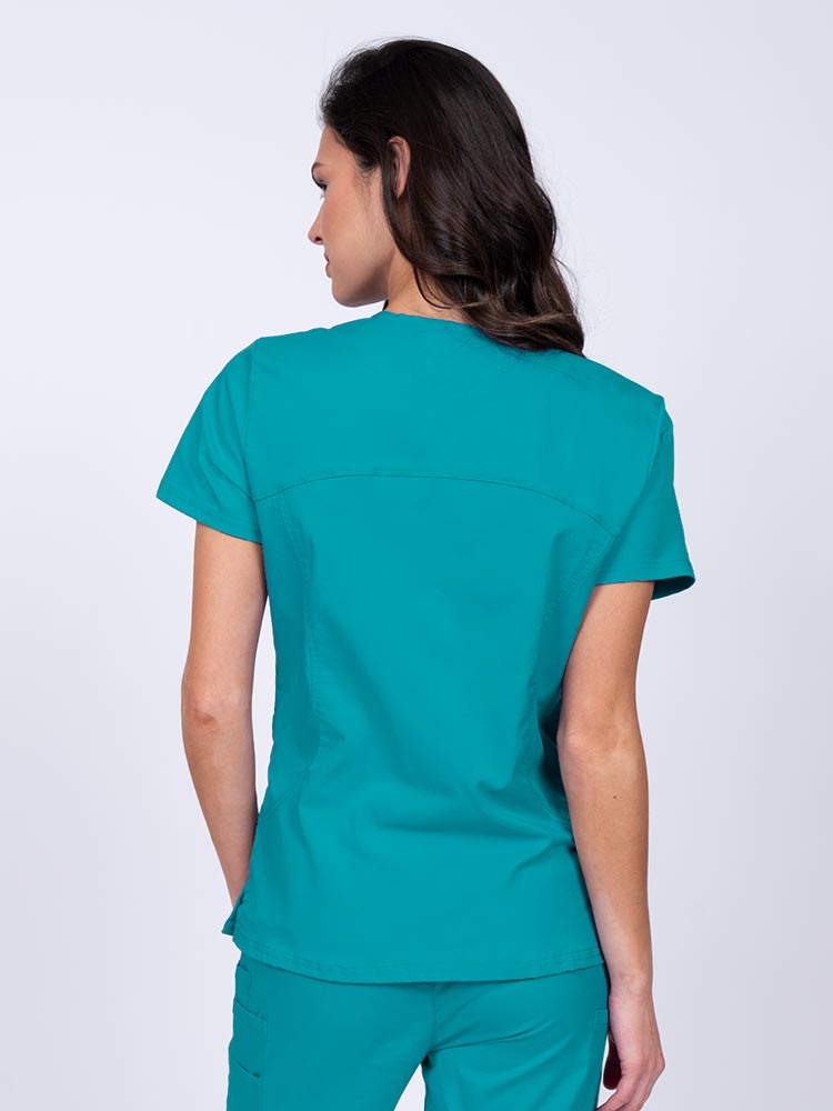 Young female nurse wearing an Epic by MedWorks Women's Knit Collar Mock Wrap Scrub Top in teal with stylish seaming throughout.