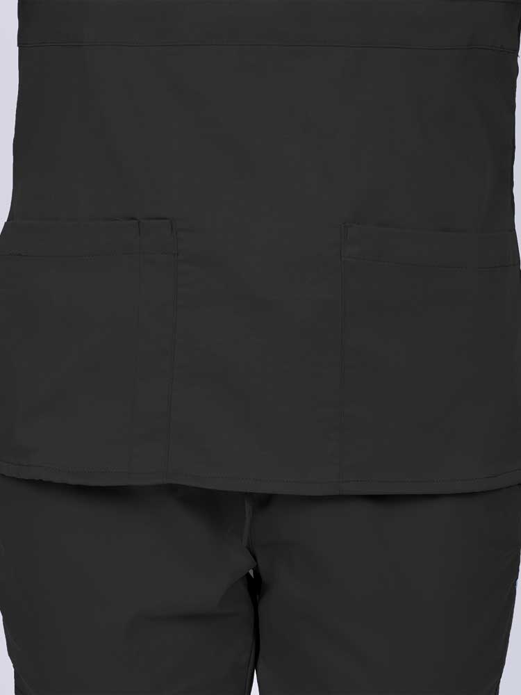 Woman wearing an Epic by MedWorks Women's Mock Wrap Scrub Top in black featuring two front patch pockets.