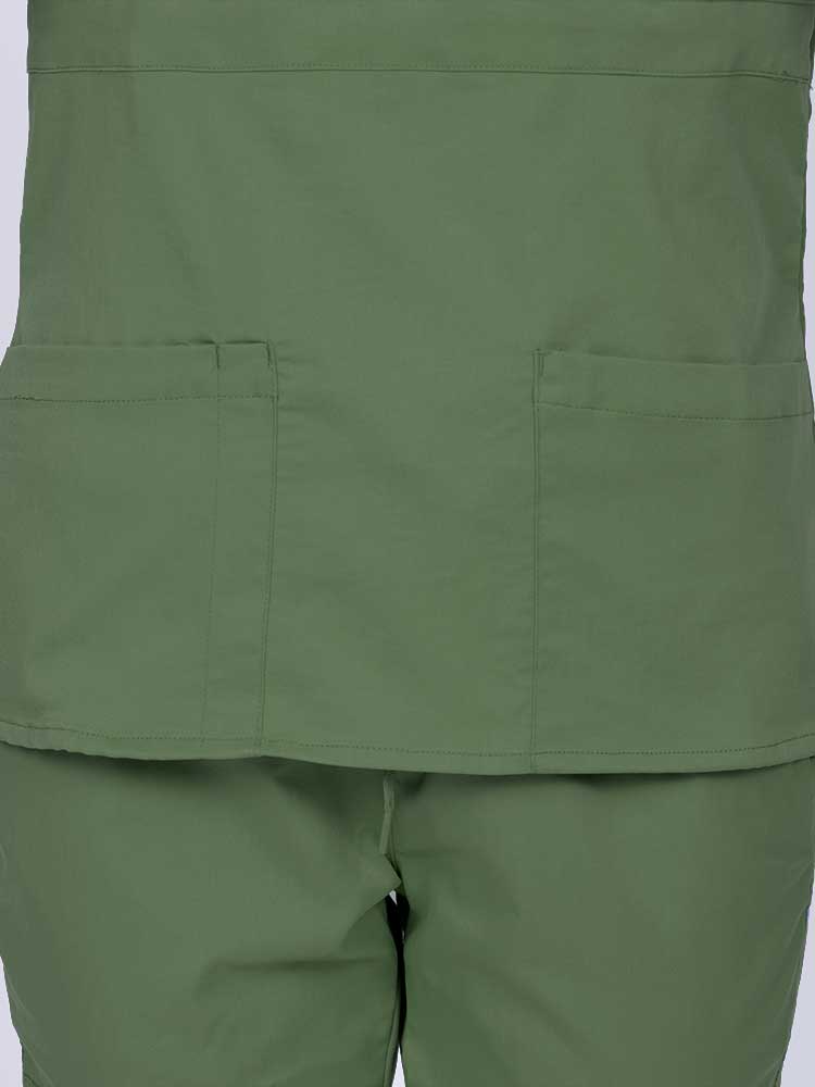 Woman wearing an Epic by MedWorks Women's Mock Wrap Scrub Top in olive featuring two front patch pockets.