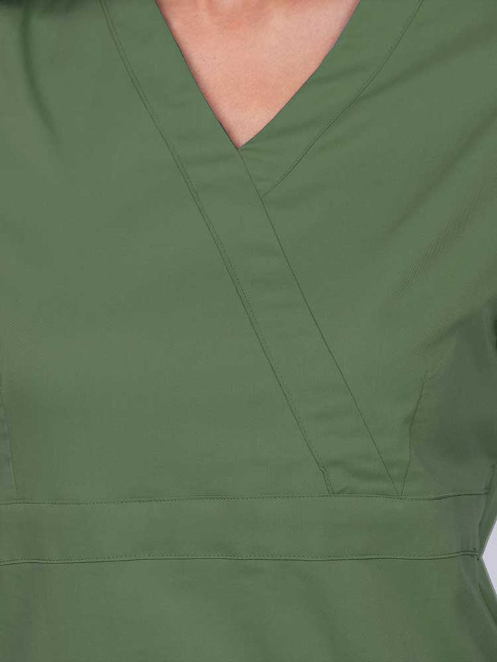 Young woman wearing an Epic by MedWorks Women's Mock Wrap Scrub Top in olive featuring a mock wrap neckline and stylish front seaming.