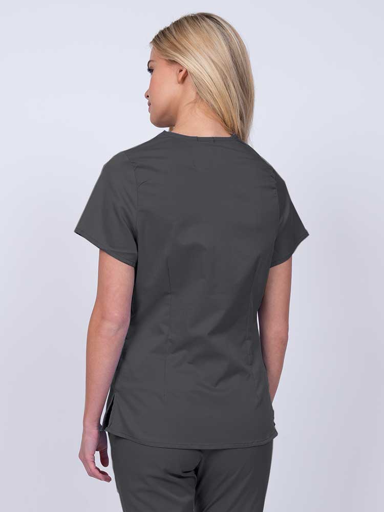 Nurse wearing an Epic by MedWorks Women's Mock Wrap Scrub Top in pewter with side slits for additional range of motion.