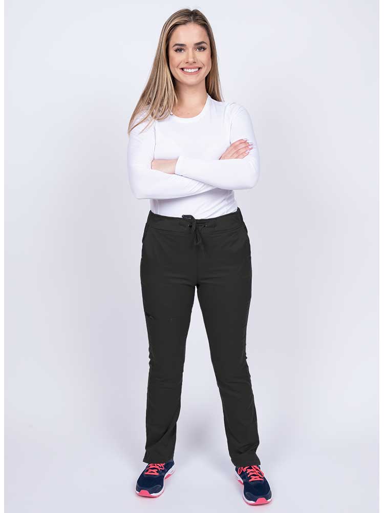 Young woman wearing an Epic by MedWorks Women's Blessed Skinny Yoga Scrub Pant in black with an adjustable waistband.
