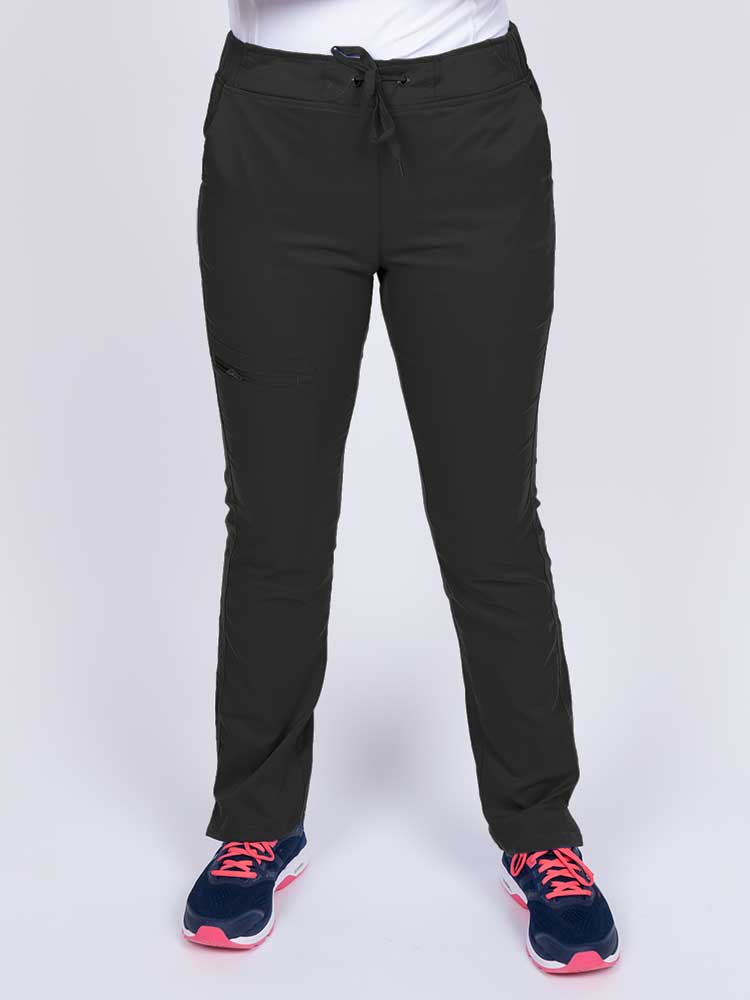 Young healthcare worker wearing an Epic by MedWorks Women's Blessed Skinny Yoga Scrub Pant in black featuring side slits for additional range of motion.
