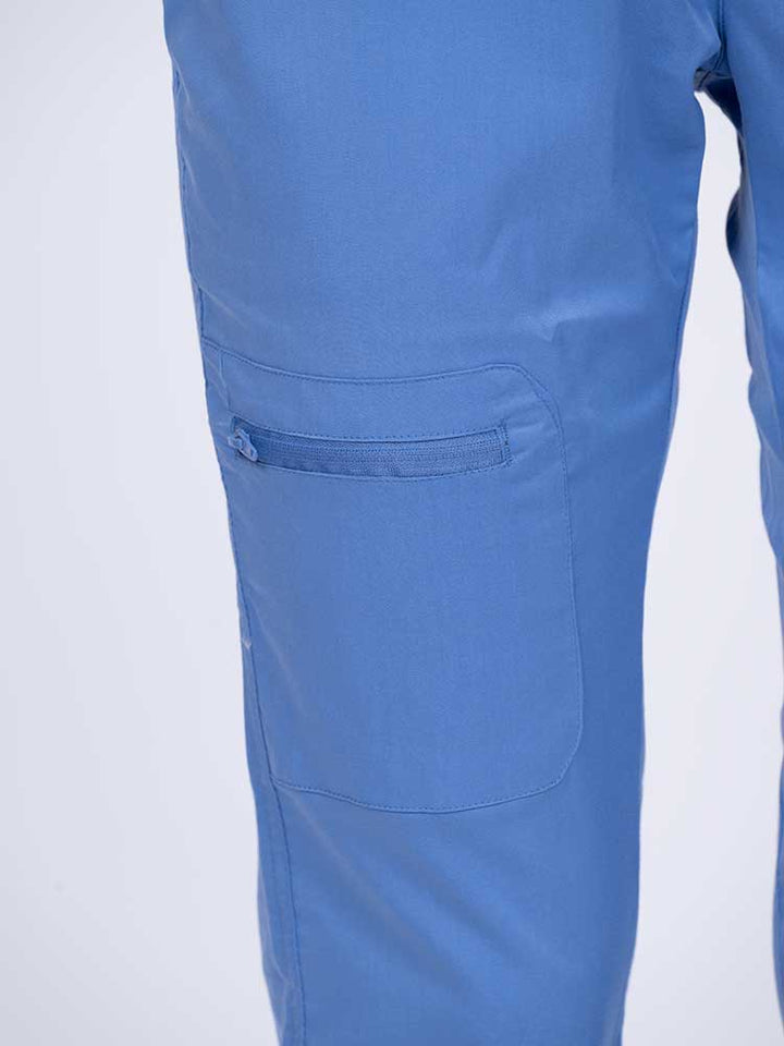 Young female nurse wearing an Epic by MedWorks Women's Blessed Skinny Yoga Scrub Pant in ceil with 1 zip closure cargo pant on the wearer's right.