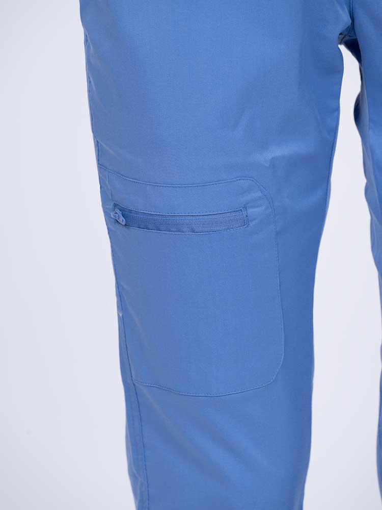 Young female nurse wearing an Epic by MedWorks Women's Blessed Skinny Yoga Scrub Pant in ceil with 1 zip closure cargo pant on the wearer's right.