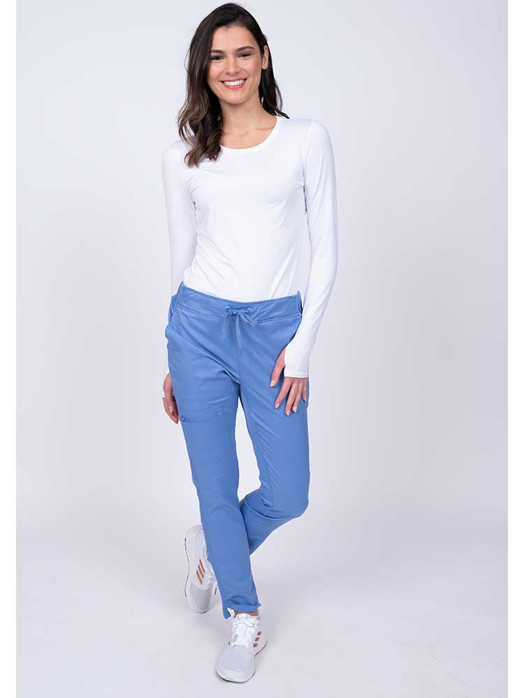 Young woman wearing an Epic by MedWorks Women's Blessed Skinny Yoga Scrub Pant in ceil with an adjustable waistband.