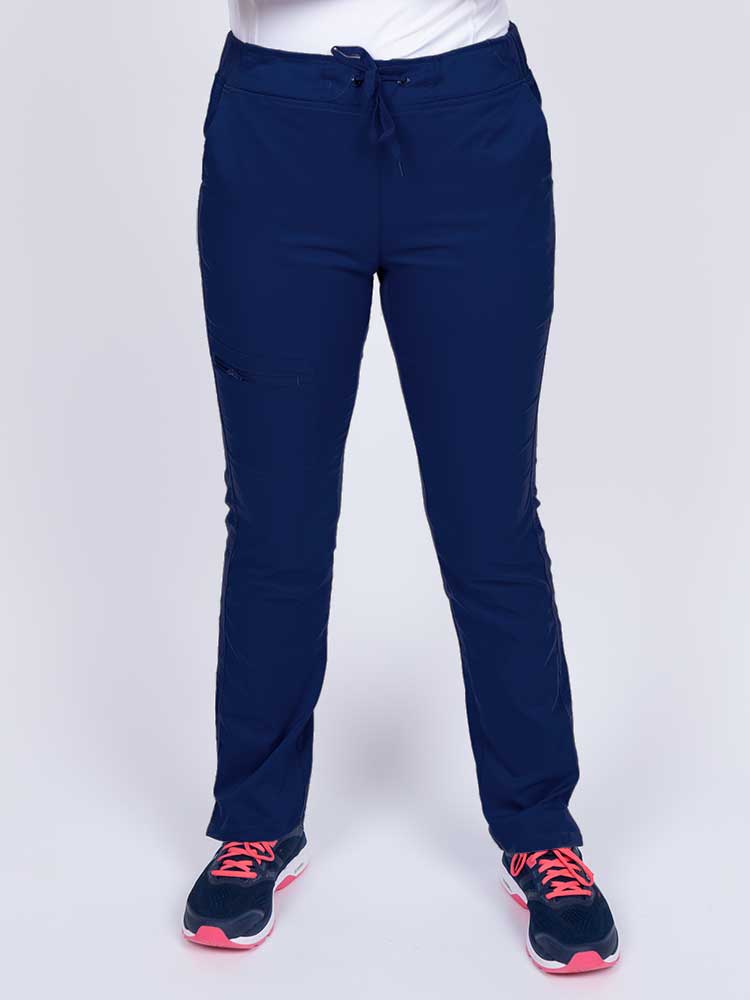 Young healthcare worker wearing an Epic by MedWorks Women's Blessed Skinny Yoga Scrub Pant in navy featuring side slits for additional range of motion.