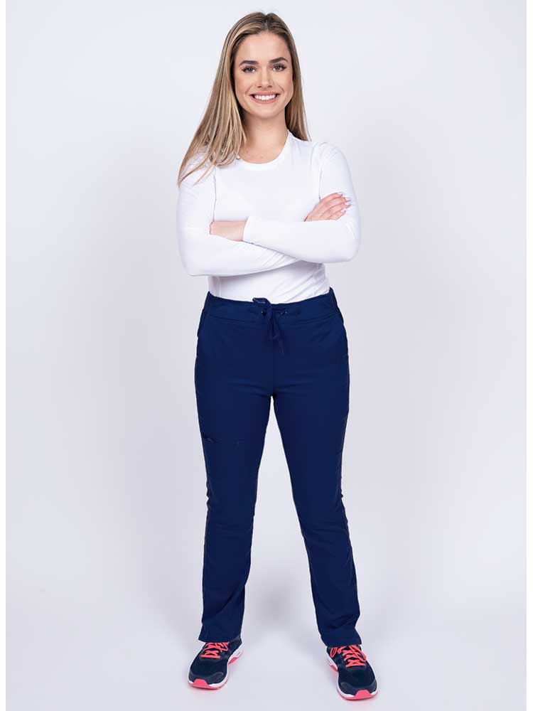 Young woman wearing an Epic by MedWorks Women's Blessed Skinny Yoga Scrub Pant in navy with an adjustable waistband.