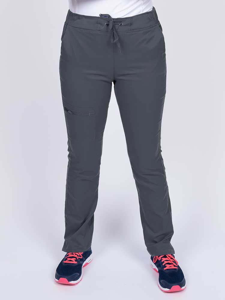 Young healthcare worker wearing an Epic by MedWorks Women's Blessed Skinny Yoga Scrub Pant in pewter featuring side slits for additional range of motion.